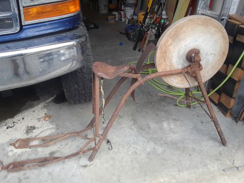 1994 Ford Bronco - Front view of a blue truck parked next to a vintage grinding wheel assembly.
