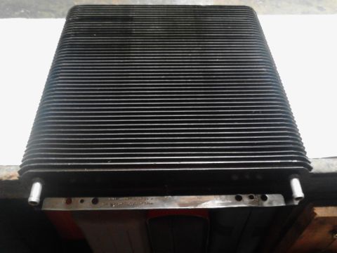 1995 Ford Bronco - Close-up of a vehicle radiator, showing its ribbed surface and mounting points.