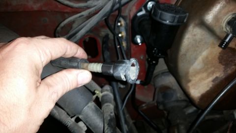 1985 Ford Bronco - Close-up of a brake fluid reservoir and a disconnected hose, likely during maintenance.