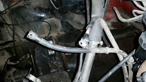 1985 Ford Bronco - Close-up view of engine bay components, including hoses and wiring, with a disconnected fuel line.