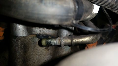1985 Ford Bronco - Engine component with a hose and clamp, likely part of a fuel or vacuum system.