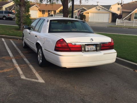 1989 Mazda MX-6 - This white sedan, likely a 2003 model, is seen from the rear with its license plate clearly visible.