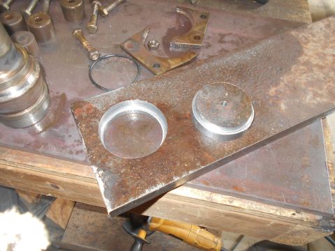 1992 Ford Bronco - A close-up view of metalworking in progress, showing a large piece of rusted metal with two circular cutouts and a cylindrical metal piece…