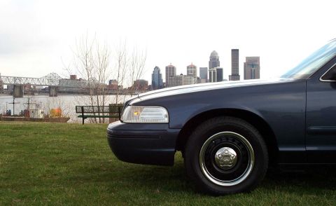 1998 Ford Crown Victoria - Front quarter view of a 1998 Ford Crown Victoria parked by a river with a city skyline.