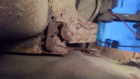 1996 Ford Bronco - This image shows heavily rusted metal components, likely part of a vehicle's undercarriage or exhaust system. The rust has caused significa…