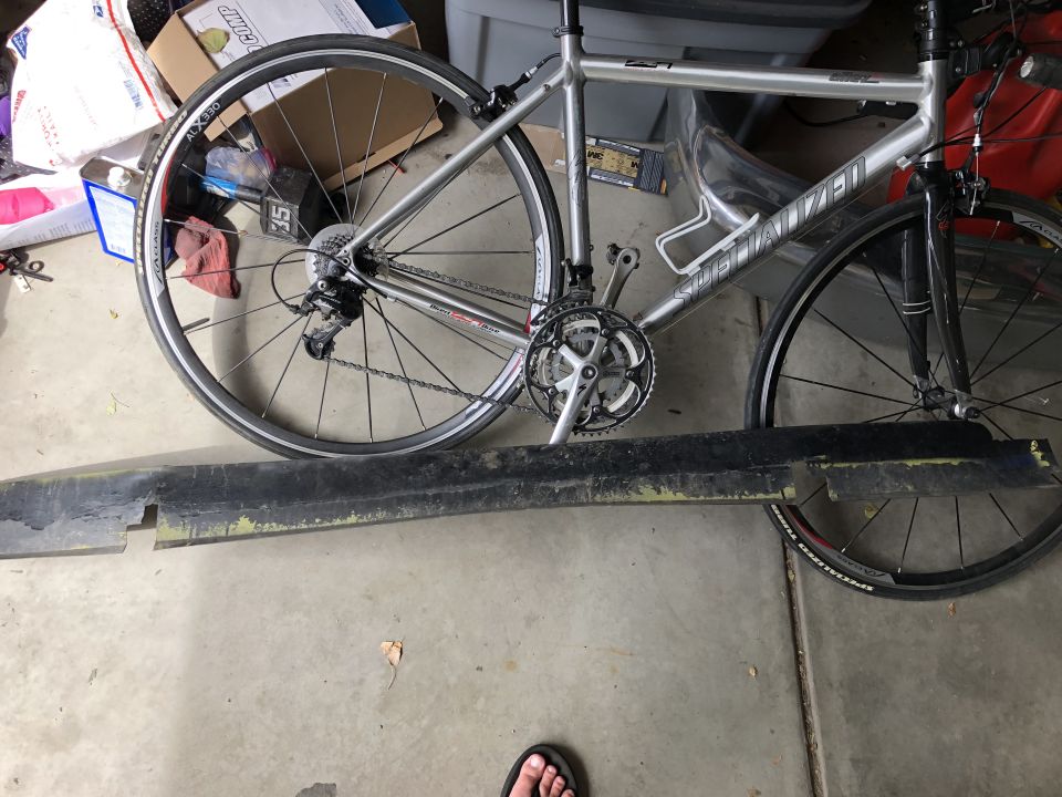 Silver Specialized Allez road bike with black and yellow bumper in foreground.
