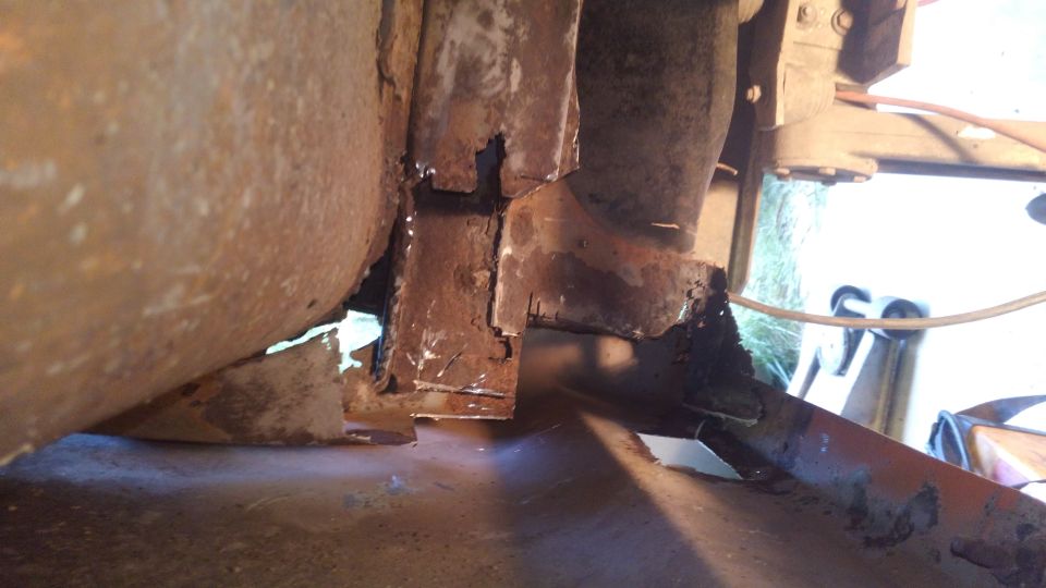 Heavily rusted metal framing and body panels, showing significant corrosion and damage.