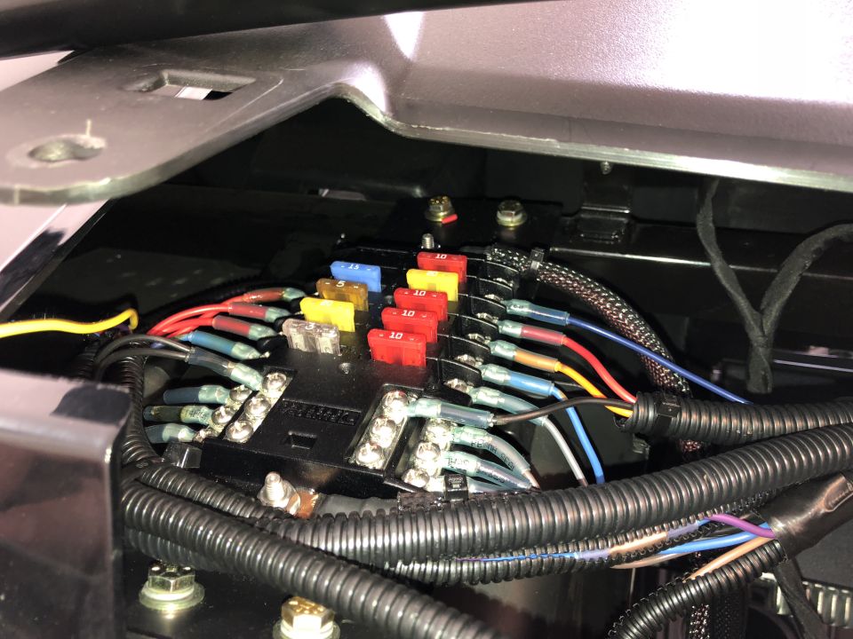 Fuse block with colorful fuses and wiring in a vehicle.