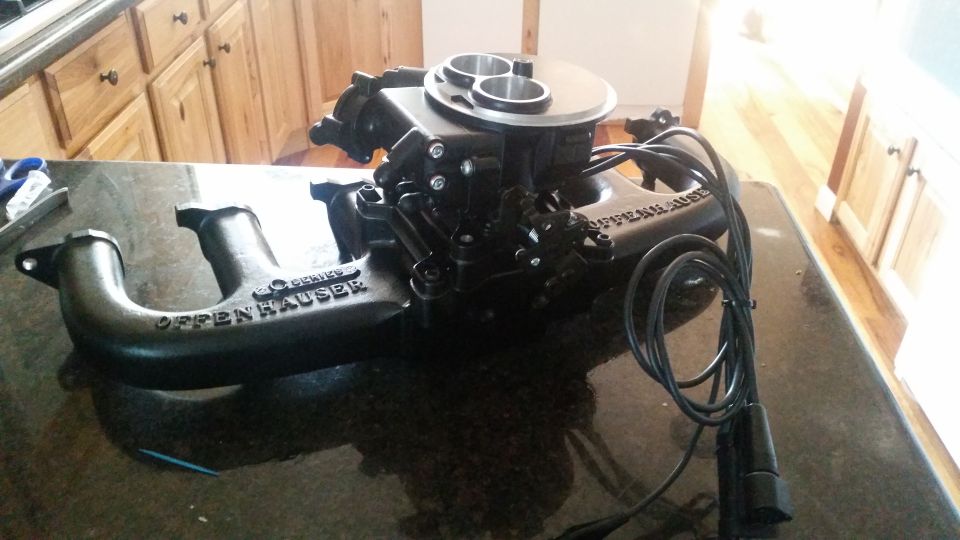 Black Offenhauser dual-quad intake manifold with carburetor on granite counter