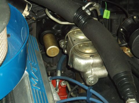 1979 Ford Ranchero - This close-up engine bay shot shows a master cylinder and brake booster assembly, along with a blue air intake housing and a portion of the…