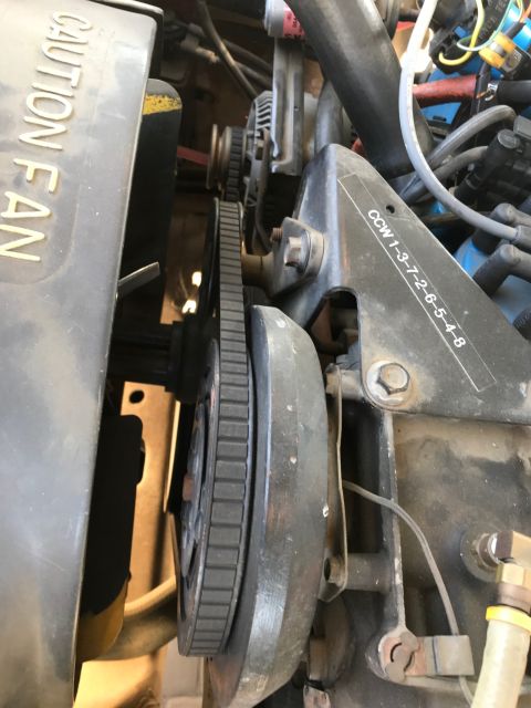1979 Ford Bronco - A close-up view of a V-belt and pulleys on an engine. The belt is black and ribbed, and it runs around a large pulley attached to the engin…