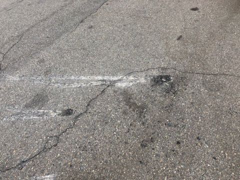 1992 Jeep Wrangler - A close-up view of an asphalt road surface showing tire marks and cracks.