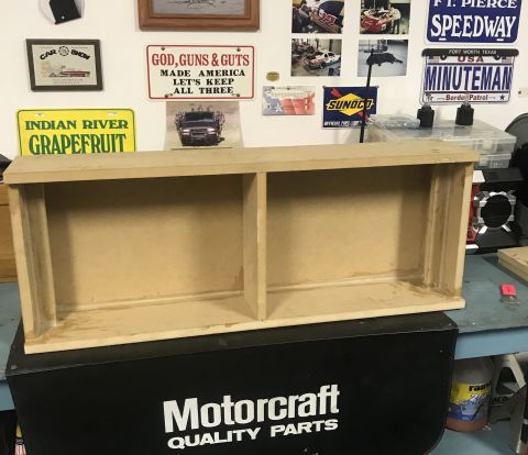 1995 Ford Bronco - A wooden shelf unit is placed on top of a black box with "Motorcraft Quality Parts" printed on it.