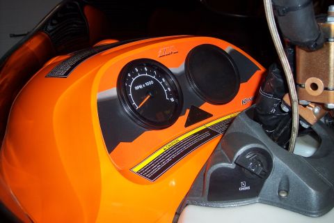 2004 Arctic Cat King Cat 900 - Close-up of a snowmobile's instrument panel, an orange body and black gauges.