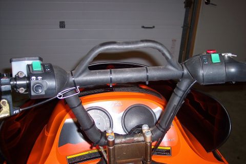 2004 Arctic Cat King Cat 900 - Close-up view of snowmobile handlebars and dashboard with orange bodywork.