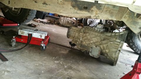 1985 Ford Bronco - Transmission removal in progress, showing the underside of the vehicle and supporting equipment.