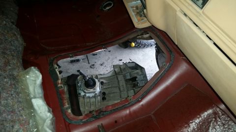 1985 Ford Bronco - Interior view of a vehicle's transmission tunnel with the gearbox exposed.