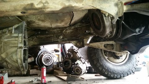 1985 Ford Bronco - The vehicle's drivetrain components are disassembled, with the transmission and transfer case visible.