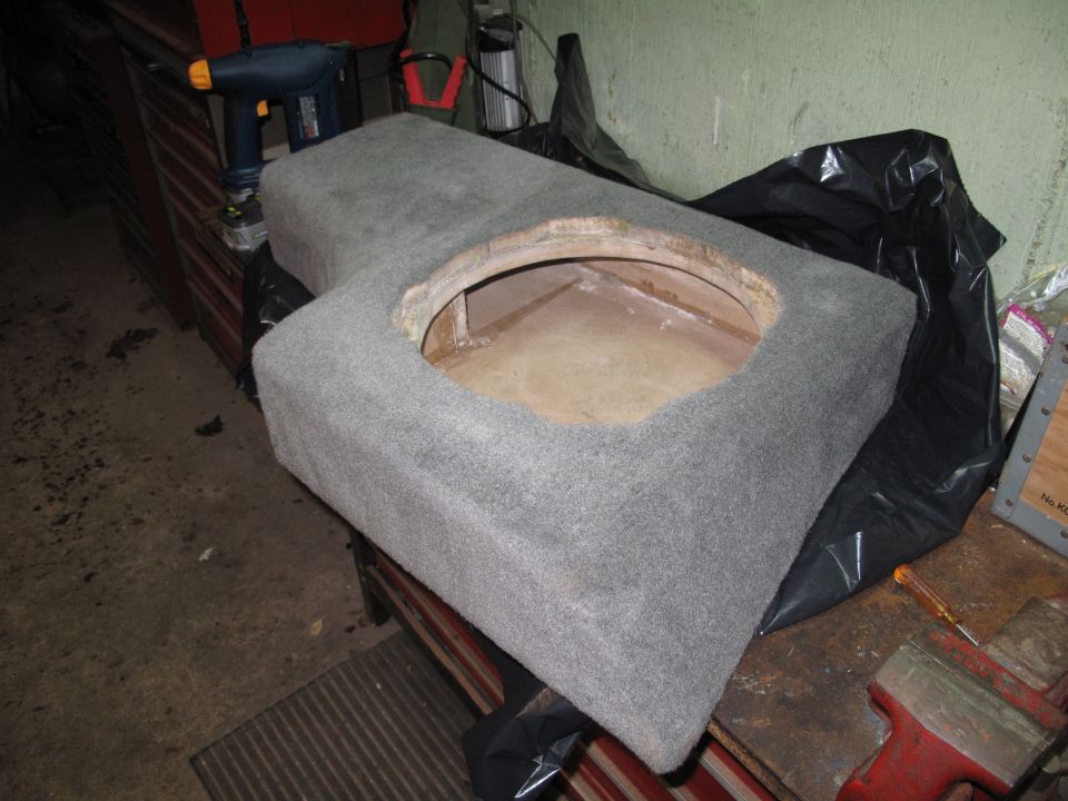 Gray carpeted subwoofer enclosure with circular cutout