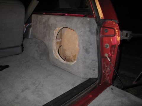 1994 Ford Bronco - A custom subwoofer enclosure is installed in the cargo area of a vehicle, ready for a speaker.