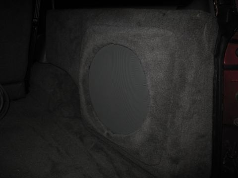 1994 Ford Bronco - This image shows a custom subwoofer enclosure built into the carpeted cargo area of a vehicle.