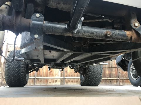 1970 Volkswagen Beetle - A low-angle view shows the complex undercarriage and suspension system of a vehicle with tires.