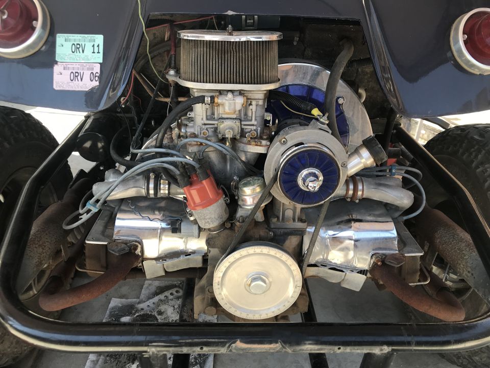 Volkswagen engine bay with turbocharger, air filter, and exhaust pipes. Two ORV stickers on fender