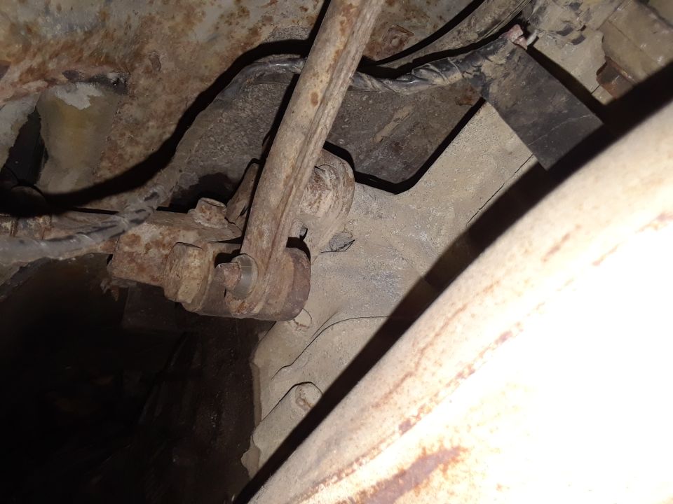 Close-up of rusty vehicle suspension components and wiring.