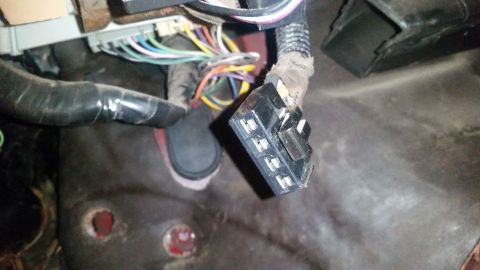 1985 Ford Bronco - A close-up view of a vehicle's wiring harness and connectors, likely under the dashboard. The image shows multiple colored wires bundled to…