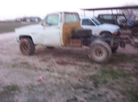 1988 Ford Bronco - This is a side view of a white truck cab and chassis, with another pickup truck in the background.