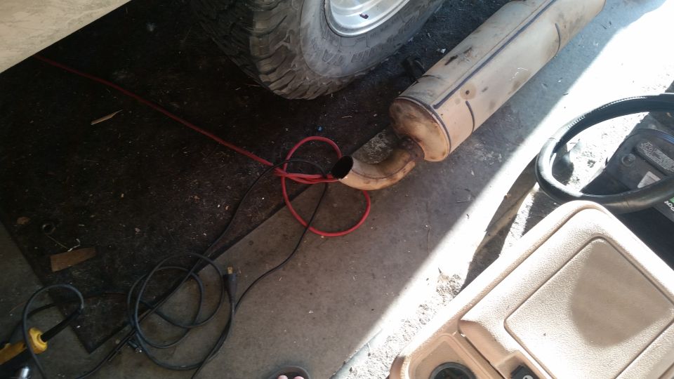 Engine bay with red fluid leak and exposed wiring