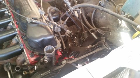 1985 Ford Bronco - A close-up view of the engine bay of a 1985 Ford Bronco, showing the valve cover, intake manifold, and various hoses and components.