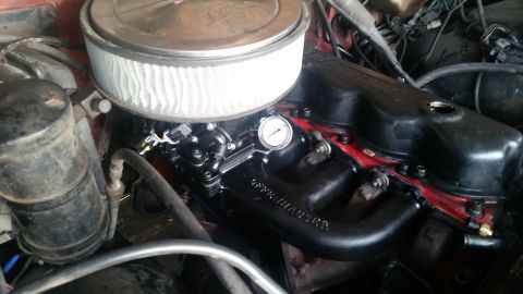 1985 Ford Bronco - A close-up view of a V8 engine, likely from a 1985 Ford Bronco, showing a black Edelbrock intake manifold, a K&N air filter, and a vacuum g…