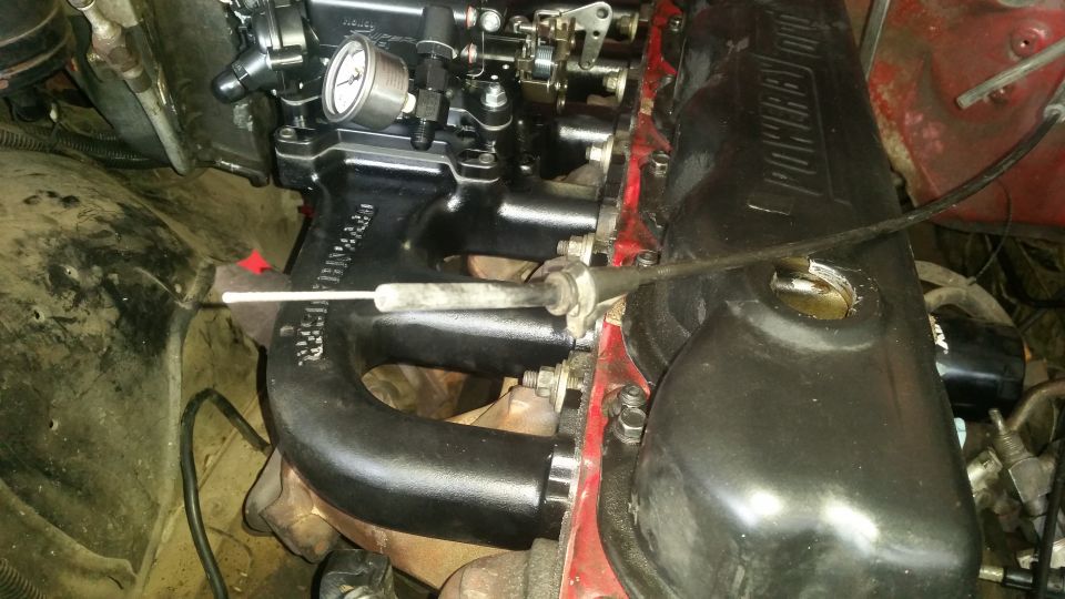 Close-up of a Ford Bronco engine bay, showing intake manifold, valve cover, and exhaust.