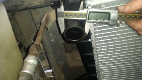 1985 Ford Bronco - A digital caliper measures the outer diameter of a black hose fitting against the fins of a radiator. The caliper reads 1.111 inches.