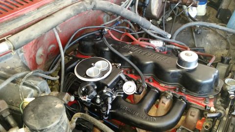 1985 Ford Bronco - Close-up view of a modified V8 engine bay, featuring a black Offenhauser intake manifold and a Holley carburetor with a chrome air cleaner…