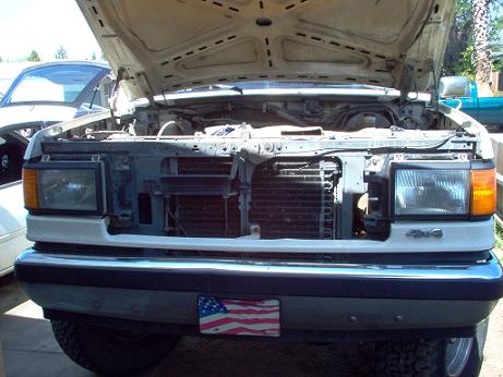1988 Ford Bronco - The front of a 1988 Ford Bronco is shown with its hood open, revealing the engine compartment and grille.