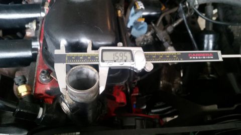 1985 Ford Bronco - A digital caliper measures the outer diameter of a metal pipe, displaying 15.95 mm. The pipe appears to be part of an engine bay with red a…