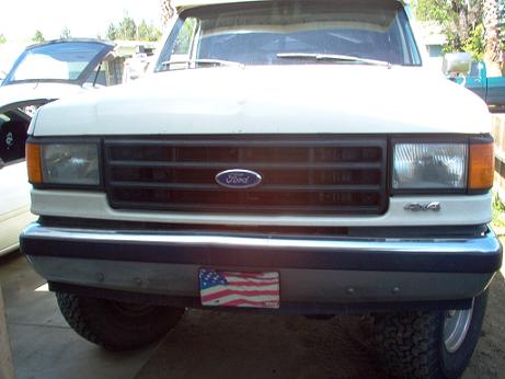 1988 Ford Bronco - Front view of a white Ford F-series truck, showing the grille and 4x4 badging.