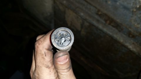 1985 Ford Bronco - A hand holds a black electrical connector with five pins visible inside a circular housing. The connector appears to be part of a vehicle's…