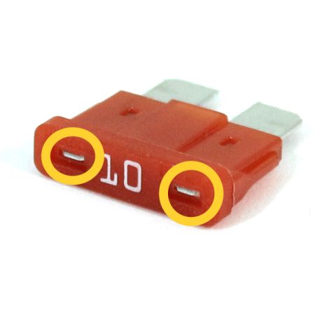 1995 Ford Bronco - A close-up shot shows a red 10-amp automotive fuse with two metal prongs. The fuse is highlighted with yellow circles around the metal pron…