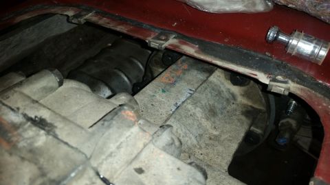1985 Ford Bronco - This close-up photo shows the underside of a vehicle, focusing on the transmission and transfer case assembly. Various metal components, bo…