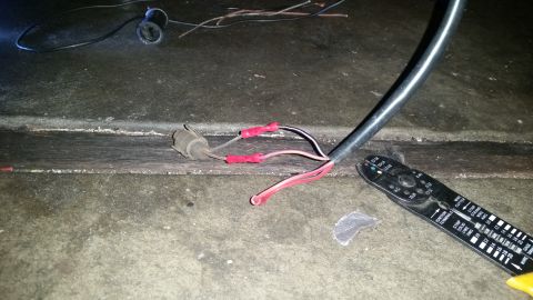 1985 Ford Bronco - A close-up view of electrical wiring being worked on. Two red wire connectors are attached to wires coming from a grey connector, and a bla…