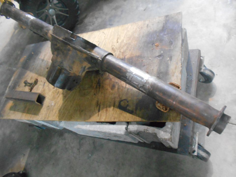 Rusty exhaust pipe assembly on a wooden workbench.