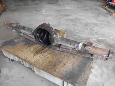 1992 Ford Bronco - A disassembled rear axle assembly, likely from a 1992 Ford Bronco, is resting on a wooden cart. The differential housing is open, revealing…