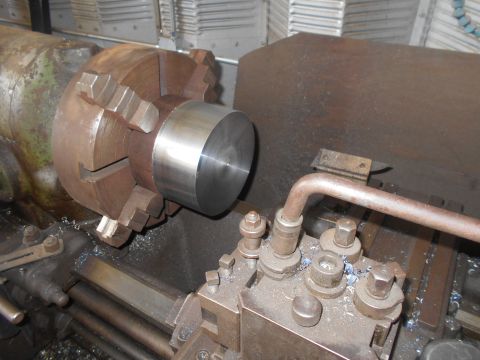 1992 Ford Bronco - A close-up view of a metal workpiece being machined on a lathe. The workpiece is held in a chuck, and a cutting tool is positioned nearby.