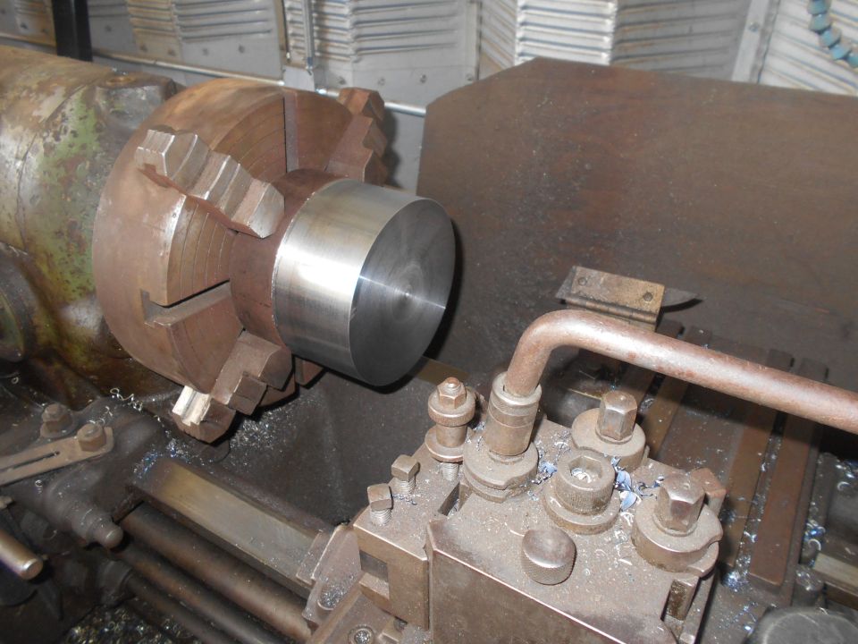 Metal workpiece being machined on a lathe