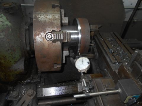 1992 Ford Bronco - A close-up view of a metal lathe setup with a dial indicator measuring a workpiece held in a chuck. Metal shavings are visible on the machi…