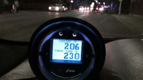 Aeroforce gauge in a car at night showing coolant temp 206°F and trans temp 230°F.
