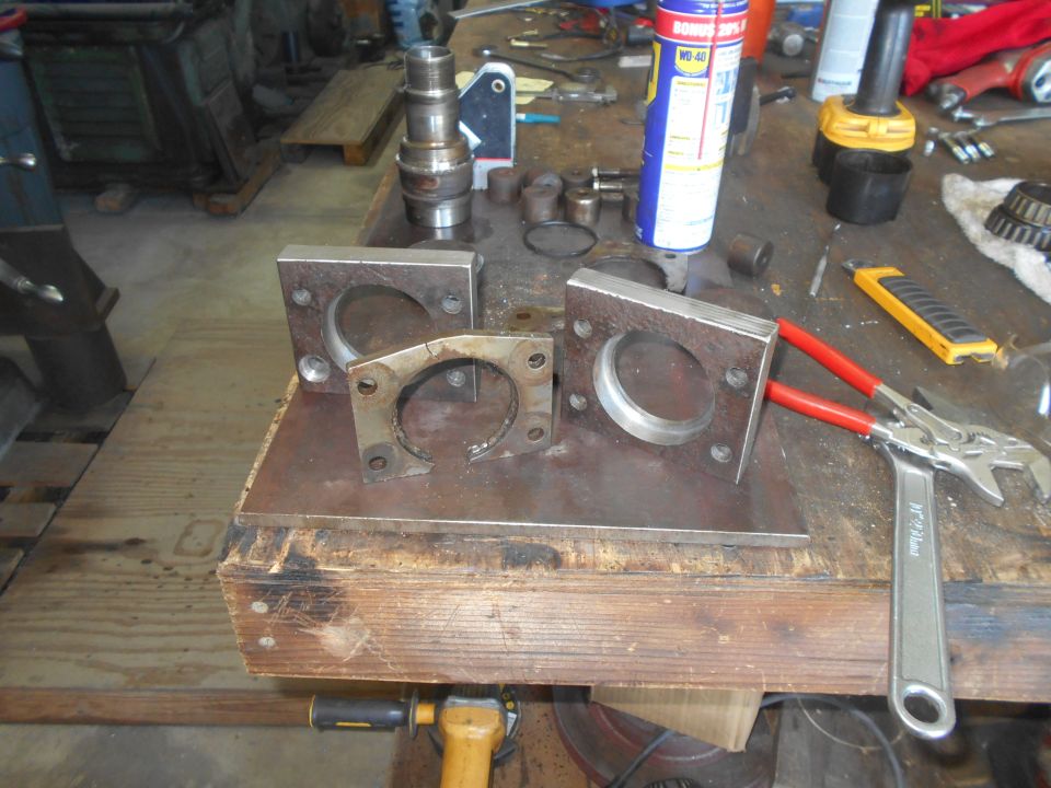 Workbench with tools and metal parts including WD-40, knife, wrench, and brackets.